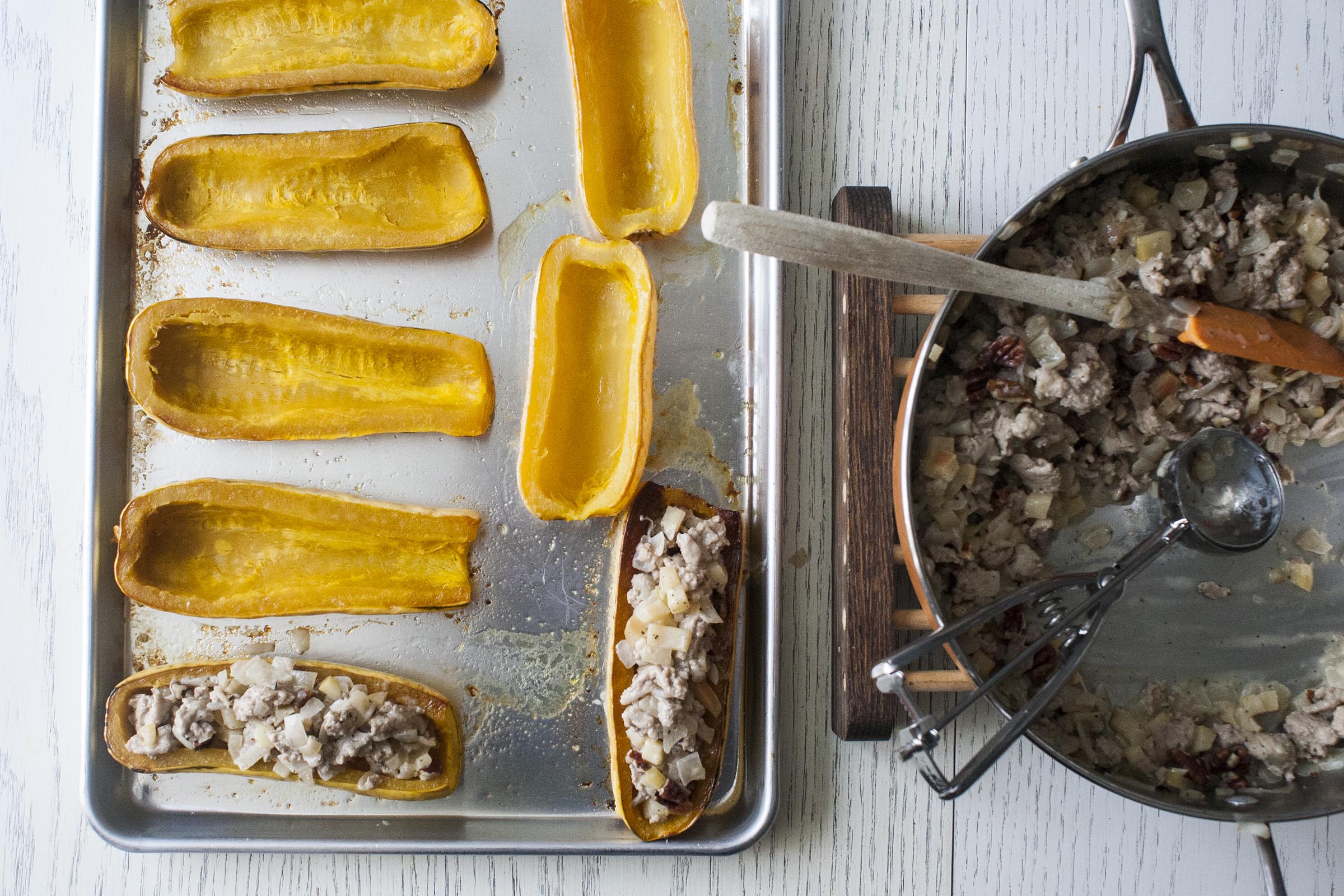 These delicata squash have been roasted and are being stuffed. 